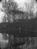 Bostadshus, en flicka.
Nya Norra Hyddan speglar sig i Pussen. Huset byggdes 1897 och bilden är nog tagen ganska snart därefter.