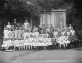 Skolbarn med lärare, skolbyggnad.