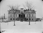 Tvåvånings bostadshus.
Skorsten/industribyggnad i bakgruden.