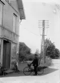 En man med cykel framför Norra Hyddan, Svennevad.