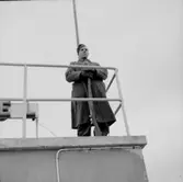 En militär står vakt mot Finland.
Bilden är nog tagen där vaktposten står på dåvarande hotell Matarengis tak mitt i Övertorneå samhälle.