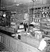 Sven Rahlén (butiksbiträde) i arbete bakom disken i Jonssons järnaffär.