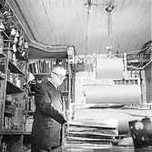 Sven Rahlén (butiksbiträde) i arbete bakom disken i Jonssons järnaffär.