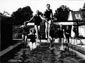 Bassängen vid Gösta Klingbergs villa i Hjärsta. Fr.v hoppar Eva Cedelind, Gunnel Klingberg, Annika Nilsson, Harriet Alexandersson, Anneli Cederlind och Margareta Bratt. Gösta Klingbergs son Bengt t.h.