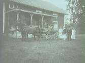 Häst och vagn utanför verandan och ett sällskap på 9 personer varav 4 personer tillhör familjen Larsson