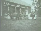 Häst och vagn utanför verandan och ett sällskap på 9 personer varav 4 personer tillhör familjen Larsson