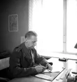 Fo-staben, kontorsinteriör, en man vid skrivbordet.
Major Hård