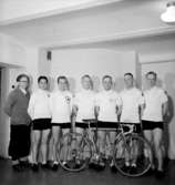 Grupp sju män och en cykel.