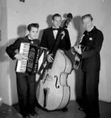 Swing-trio, tre män med musikinstrument (dragspel, bas och gitarr). Sven Charlies Ensemble, Örebro. Fr. v. Sven Charlie Falk, dragspel och piano. Arne Olows, bas. Lasse Karlsson, gitarr och trumpet.