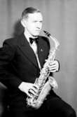 En man med musikinstrument (saxofon).
Aldor Berg