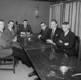Rumsinteriör, grupp sex män vid bordet, styrelsen.