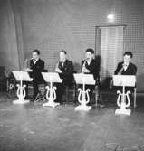 Whispering Band, fyra män med musikinstrument.