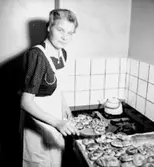 Rumsinteriör, bakning, en kvinna.
Fru Hellkvist
Konsum