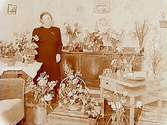 Rumsinteriör, en kvinna.
Fru Karlsson, högtidsdag (födelsedag).
Adolfsberg, Örebro.
