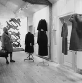 Klädutställning i Wadköping, interiör av utställningssalen, en kvinna.