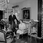 Rumsinteriör, familjegrupp tre personer.
K.G. Larssons 50-årsdag.