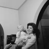 Rumsinteriör, familjegrupp, en kvinna och en liten flicka.
Docent Lennart Åqvist