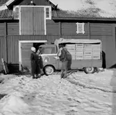 Stubbetorps Kontrollhönseri, lastbil och två personer.
Byggnad.