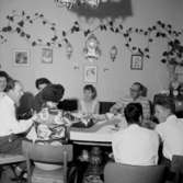 Rumsinteriör, familjegrupp vid bordet.Jönsson