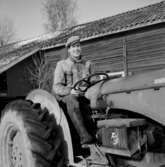 En man med traktor. Byggnad.
Lantbrukare Bengt Johansson
Oscaria (beställare ?).