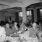 Rumsinteriör, grupp vid bordet, Oscarias pensionärer. Avtackning.