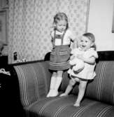 Rumsinteriör, två småflickor i soffan.Beijer