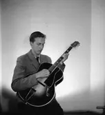 En man med musikinstrument (gitarr).
Åke Andersson