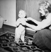 Rumsinteriör, en kvinna och ett litet barn.Sjunnesson