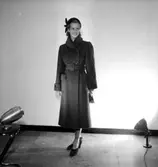 En kvinna.
Damkonfektion från Konsum.