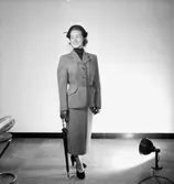 En kvinna.
Damkonfektion från Konsum.