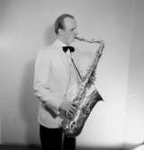 En man med musikinstrument (saxofon).
Lundkvist, Astoria orkester.
