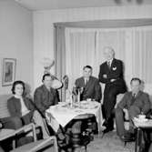 Rumsinteriör, fem personer vid bordet.
Gösta Karlbergs 50-årsdag.