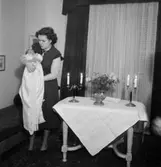 Rumsinteriör, en kvinna och ett litet barn. Barndop.
Eklund