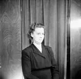 En kvinna.
Kläder från Jörnstedts damekipering.