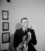 Rumsinteriör, en man med musikinstrument (fiol).
Storå