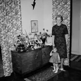 Rumsinteriör, en kvinna och en liten flicka.
Födelsedag.