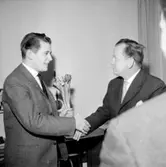 Interiör, två män, uppvaktning.
Wigrell & Co.