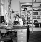 Verkstadsinteriör, en man.
Original Adhner, skrivmaskiner.
