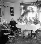 Rumsinteriör, en kvinna.
Fru Olga Andersson på 60-årsdagen.