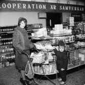 Konsum, affärsinteriör, en kvinna och en liten flicka.