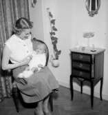 Rumsinteriör, en kvinna och en baby.Bigge Holmberg