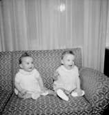 Rumsinteriör, två småflickor i soffan.Fru Blomberg