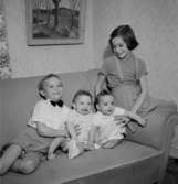 Rumsinteriör, fyra barn i soffan.Fru Blomberg