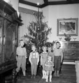 Rumsinteriör, grupp sex barn vid julgranen.
Lennart Larssons 5-årskalas.