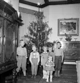 Rumsinteriör, grupp sex barn vid julgranen.
Lennart Larssons 5-årskalas.