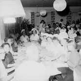 Rumsinteriör, grupp vid bordet, Luciafirande.
Örebro Kexfabrik.