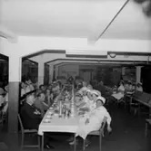 Rumsinteriör, grupp vid bordet, Luciafirande.
Örebro Kexfabrik.