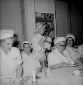 Rumsinteriör, grupp vid bordet, Luciafirande.
Örebro Kexfabrik.