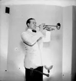 En man med musikinstrument (trumpet).