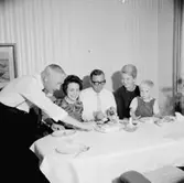 Rumsinteriör, grupp fem personer vid bordet.
Hos Nisse och Kerstin.